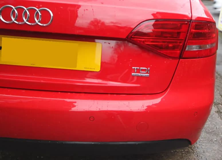 The same red Audi with its front bumper repaired and refinished.