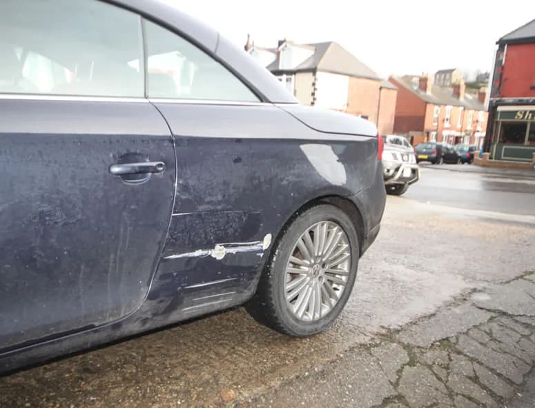 Blue Volkswagen Eos with a scraped and dented rear quarter panel and sill